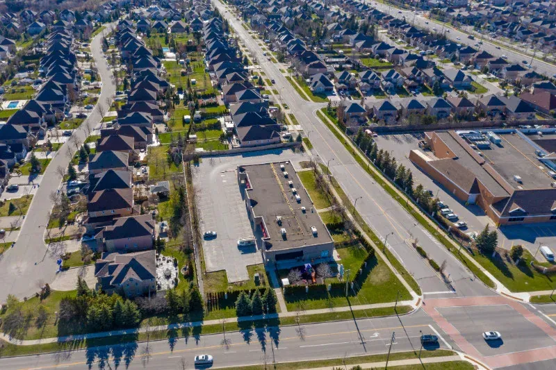 An aerial view of a residential area with lots of houses and a parking lot.