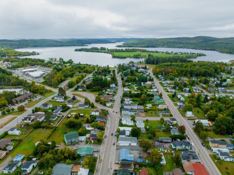 An aerial view of a small town with a lake in the background.