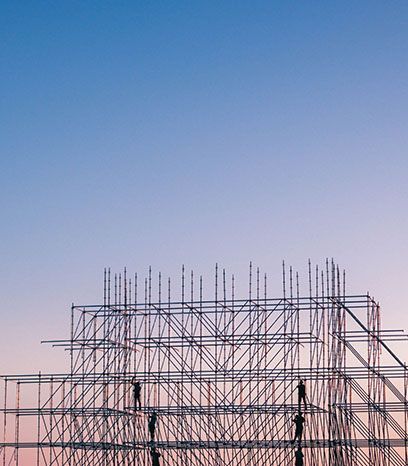 A building under construction with scaffolding against a blue sky