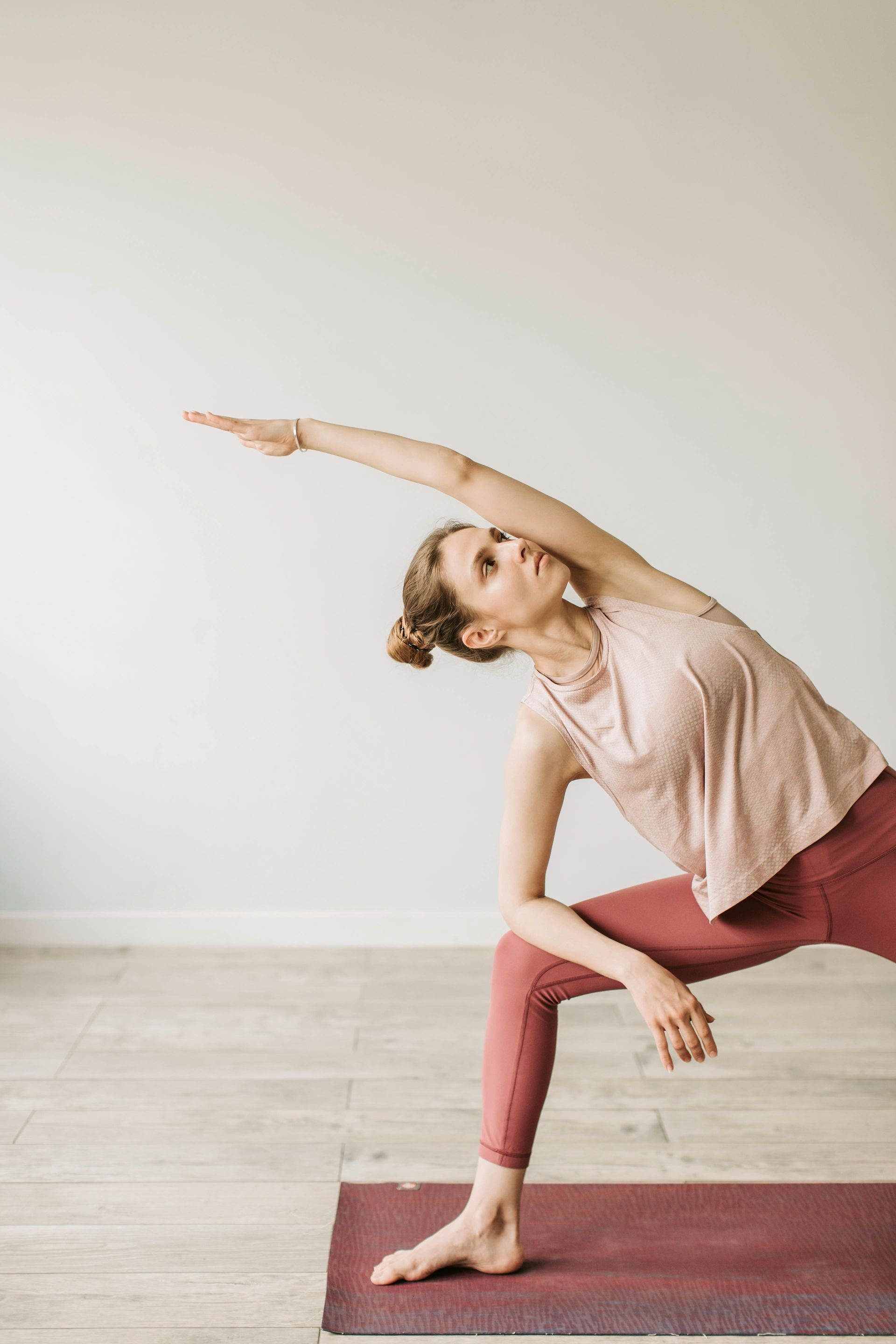 A woman is doing yoga on a mat in a room.
