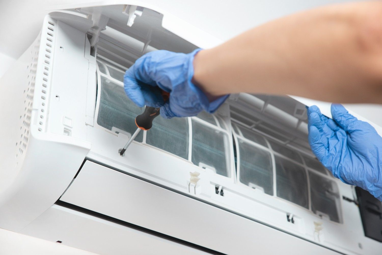 Person Working on An Air Conditioner — Gordon's Air Conditioning & Refrigeration Services in Mapleton, QLD