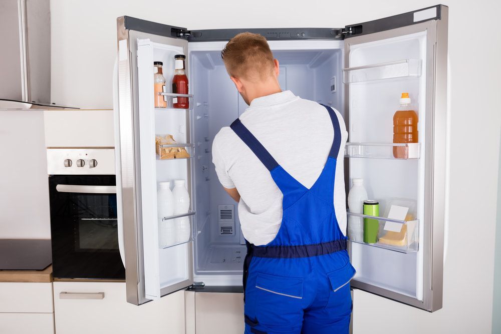 Repairing a Refrigerator in A Kitchen — Gordon's Air Conditioning & Refrigeration Services in Caloundra, QLD