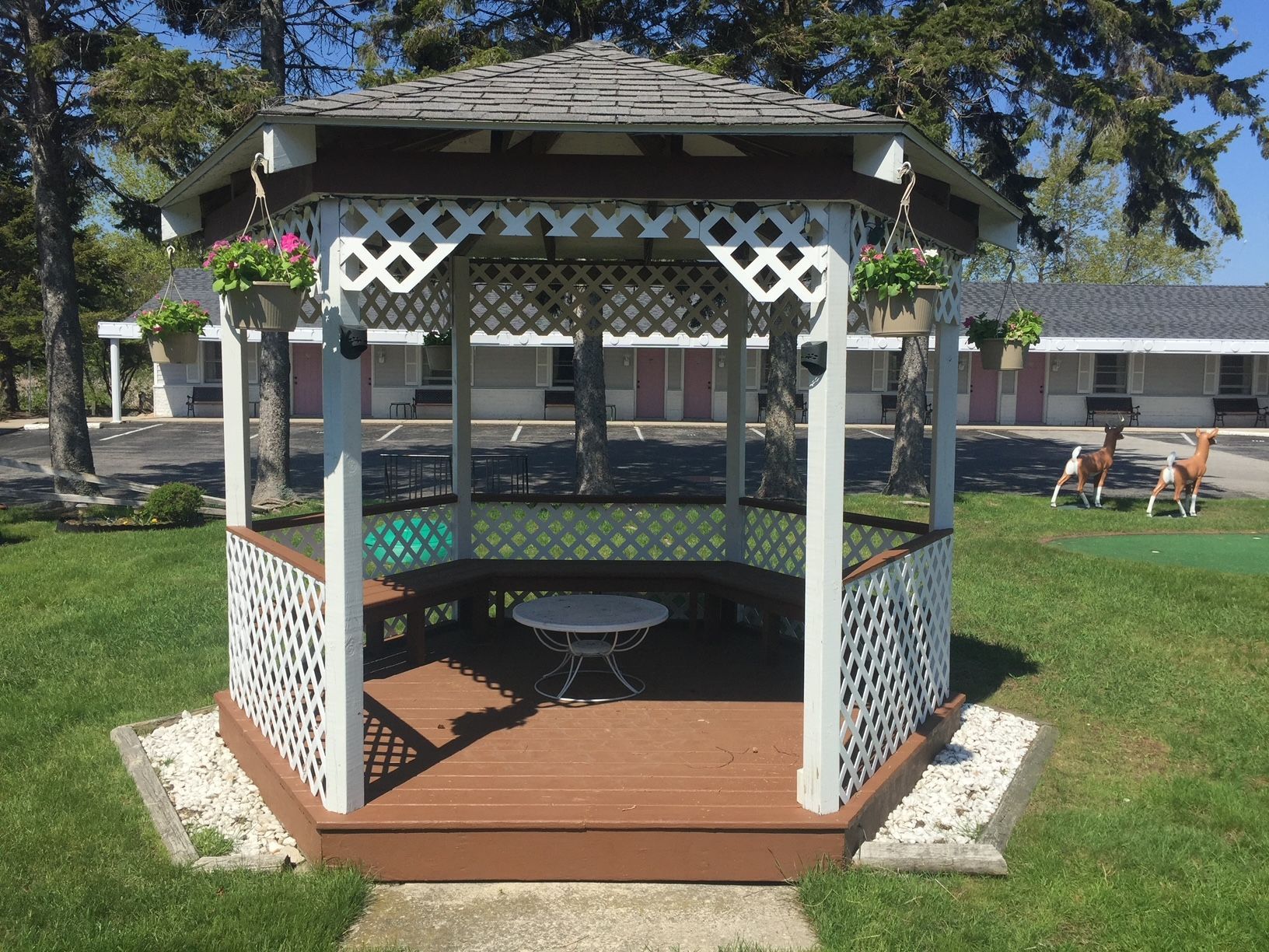 A gazebo with a table in the middle of a lush green field.