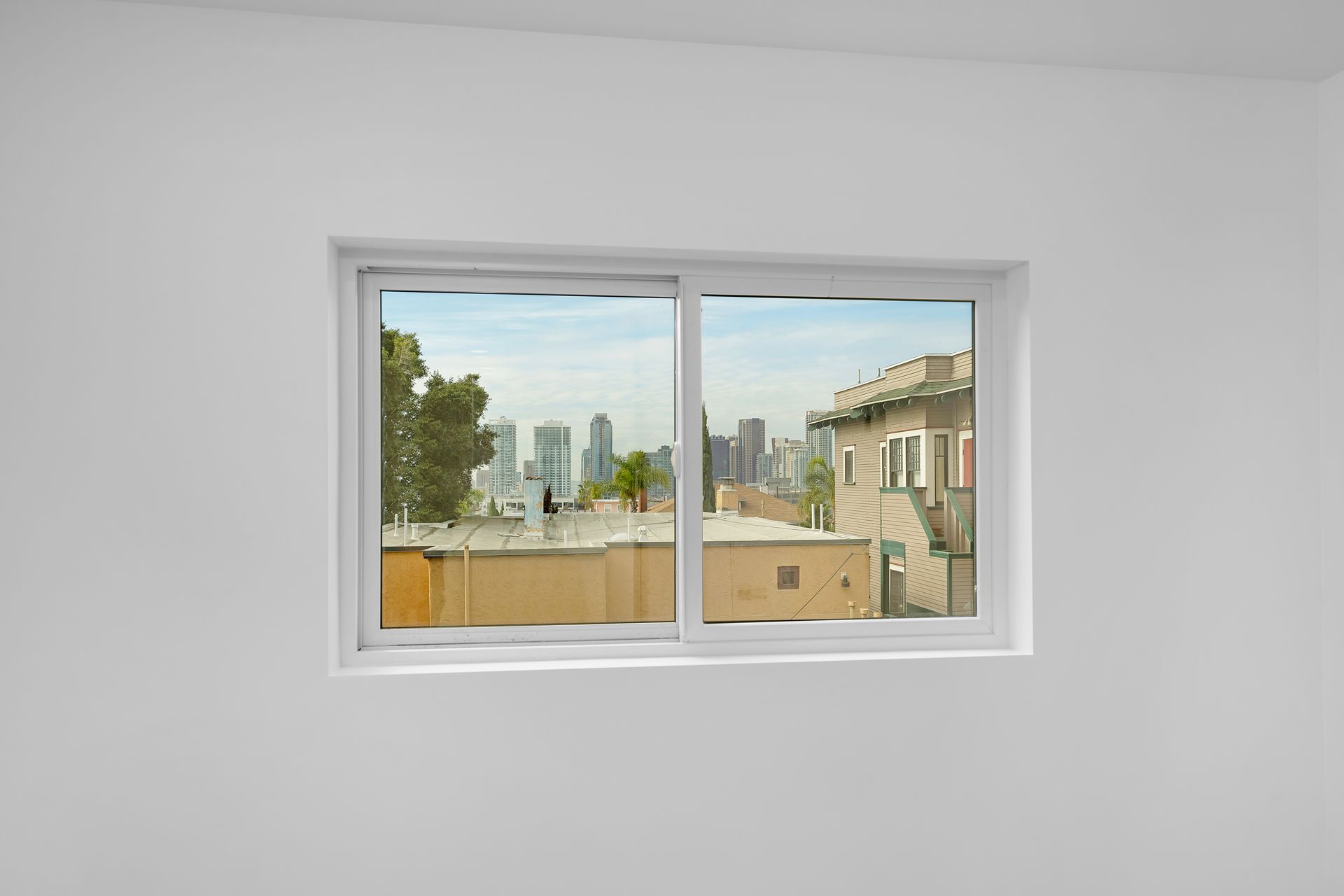 A white window with a view of a city skyline.