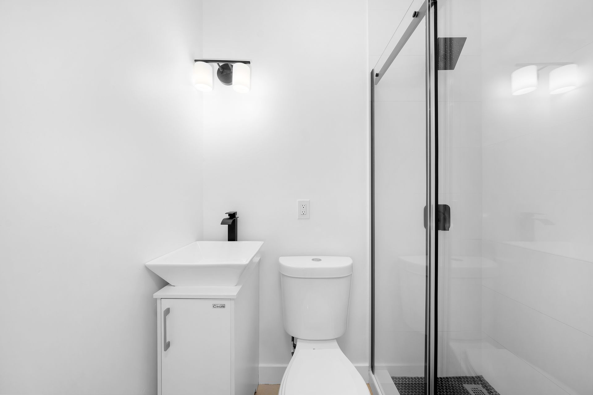 A bathroom with a toilet , sink and shower stall.