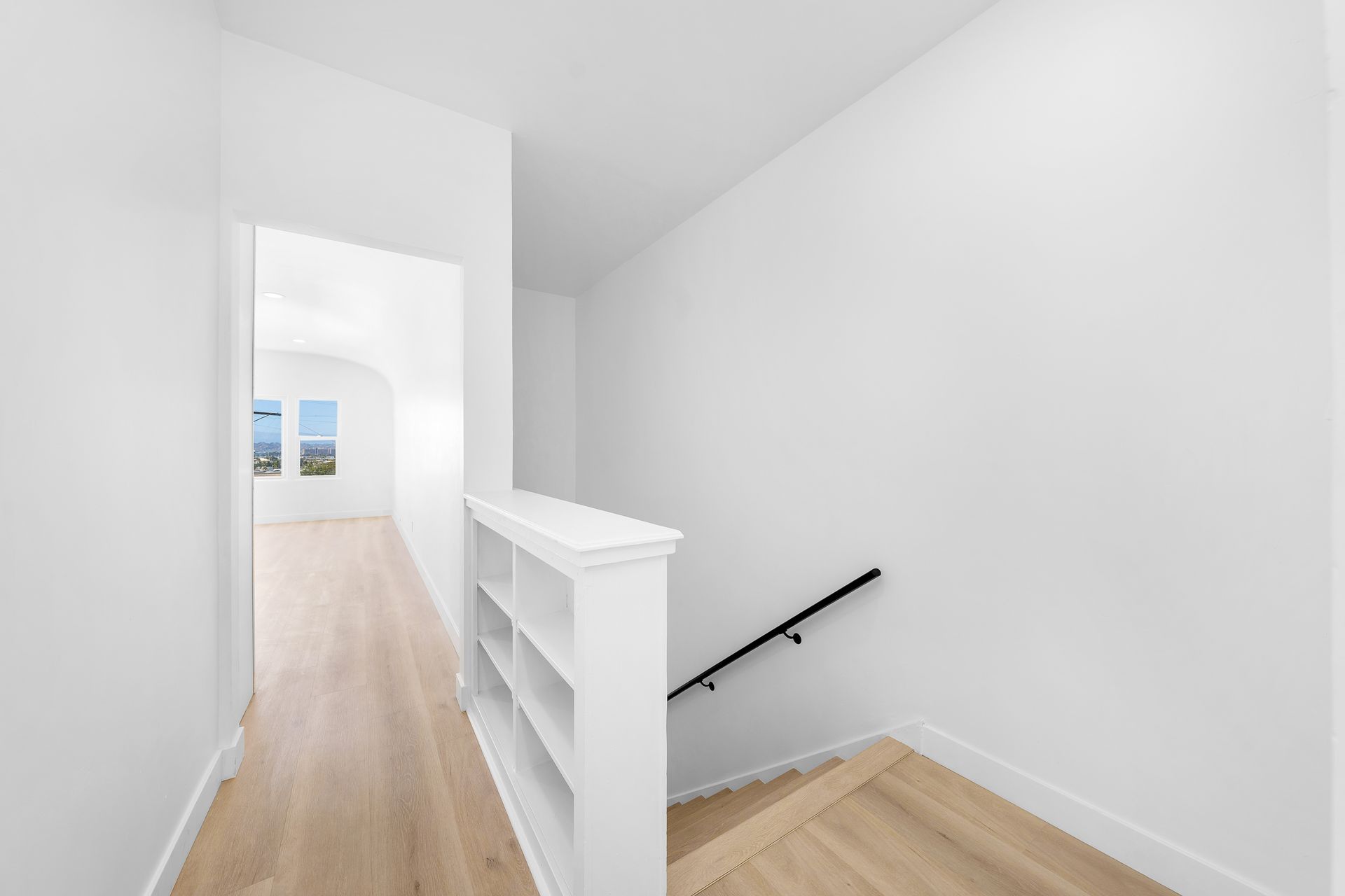 A hallway with a staircase leading up to the second floor of a house.
