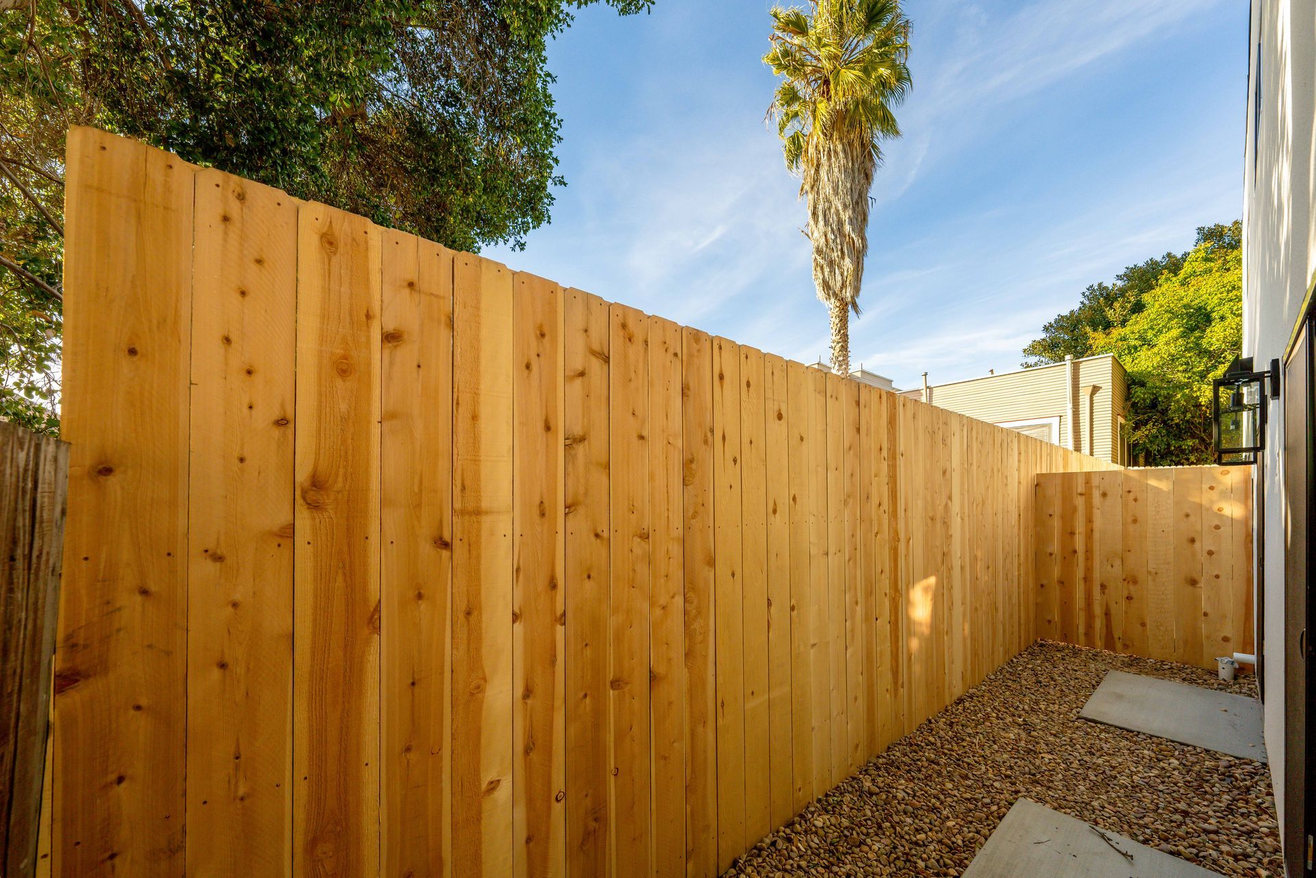 There is a wooden fence in the backyard of a house.