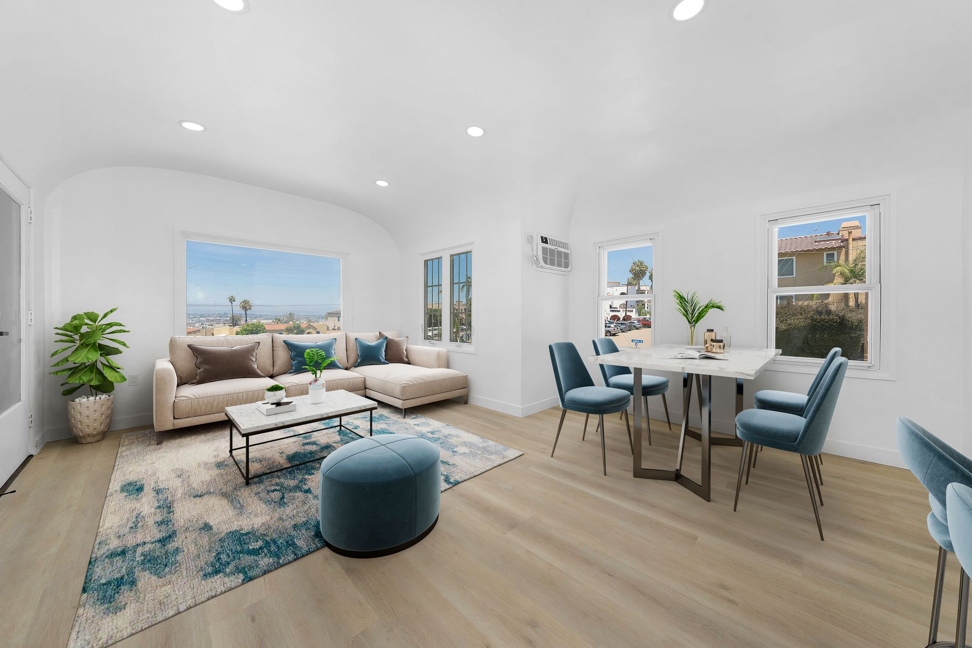 A living room with a couch , table , chairs and a rug.