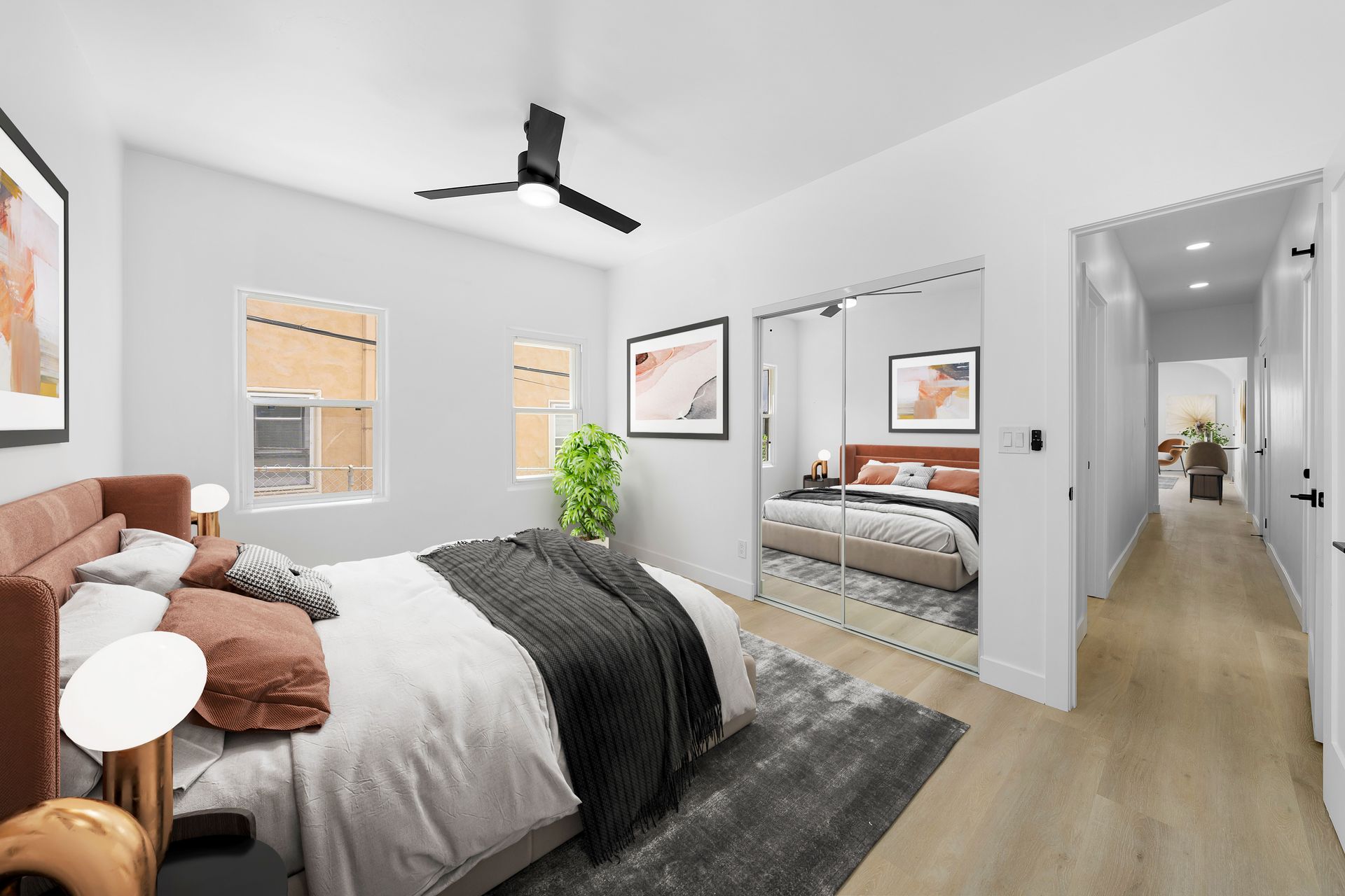 A bedroom with a large bed and a ceiling fan.