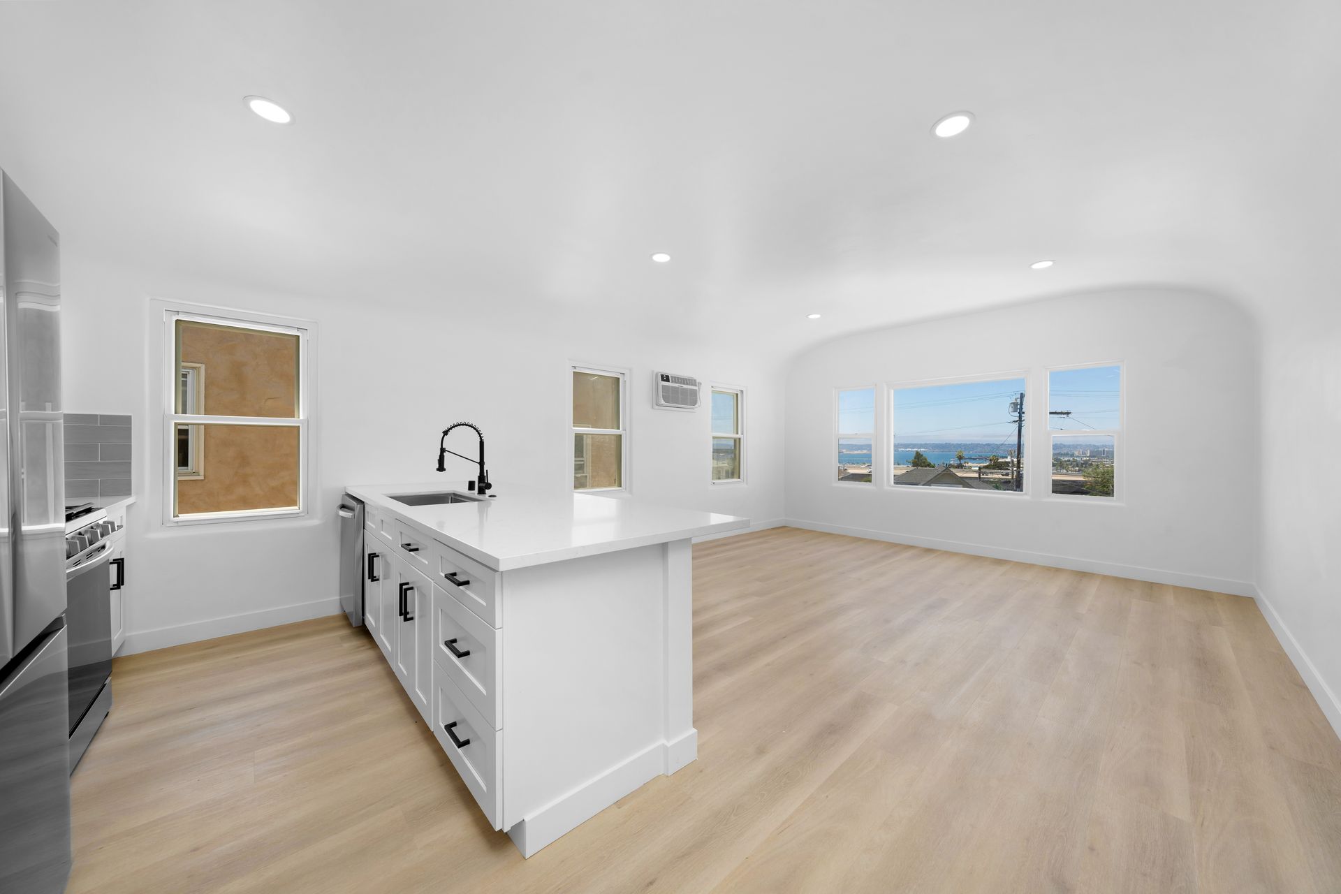 An empty kitchen with a large island in the middle of the room.