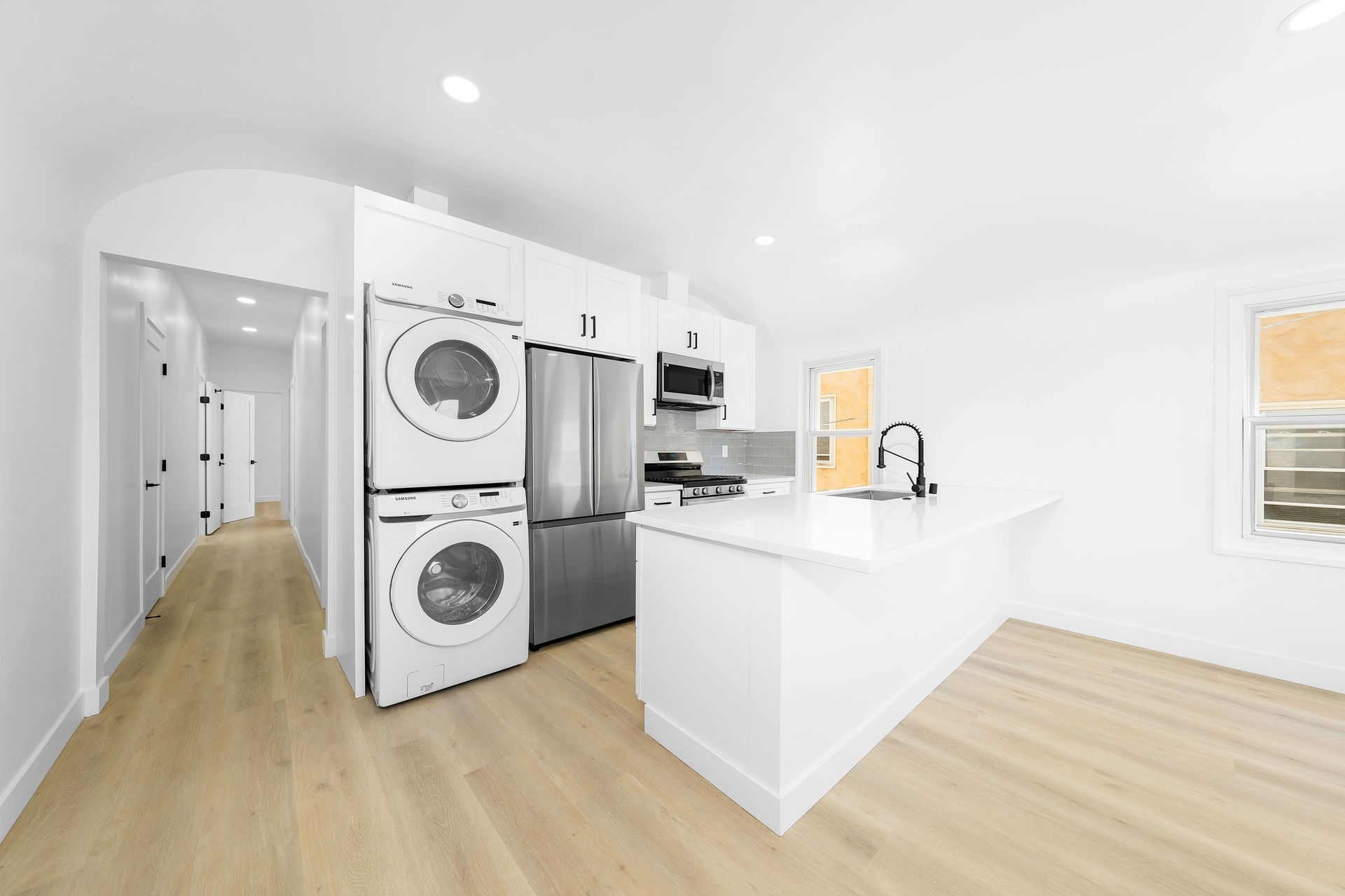 A kitchen with a washer and dryer stacked on top of each other.