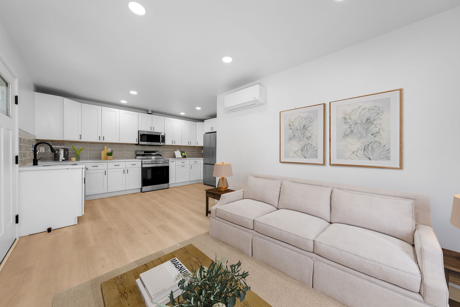 A living room with a couch , coffee table , and kitchen.