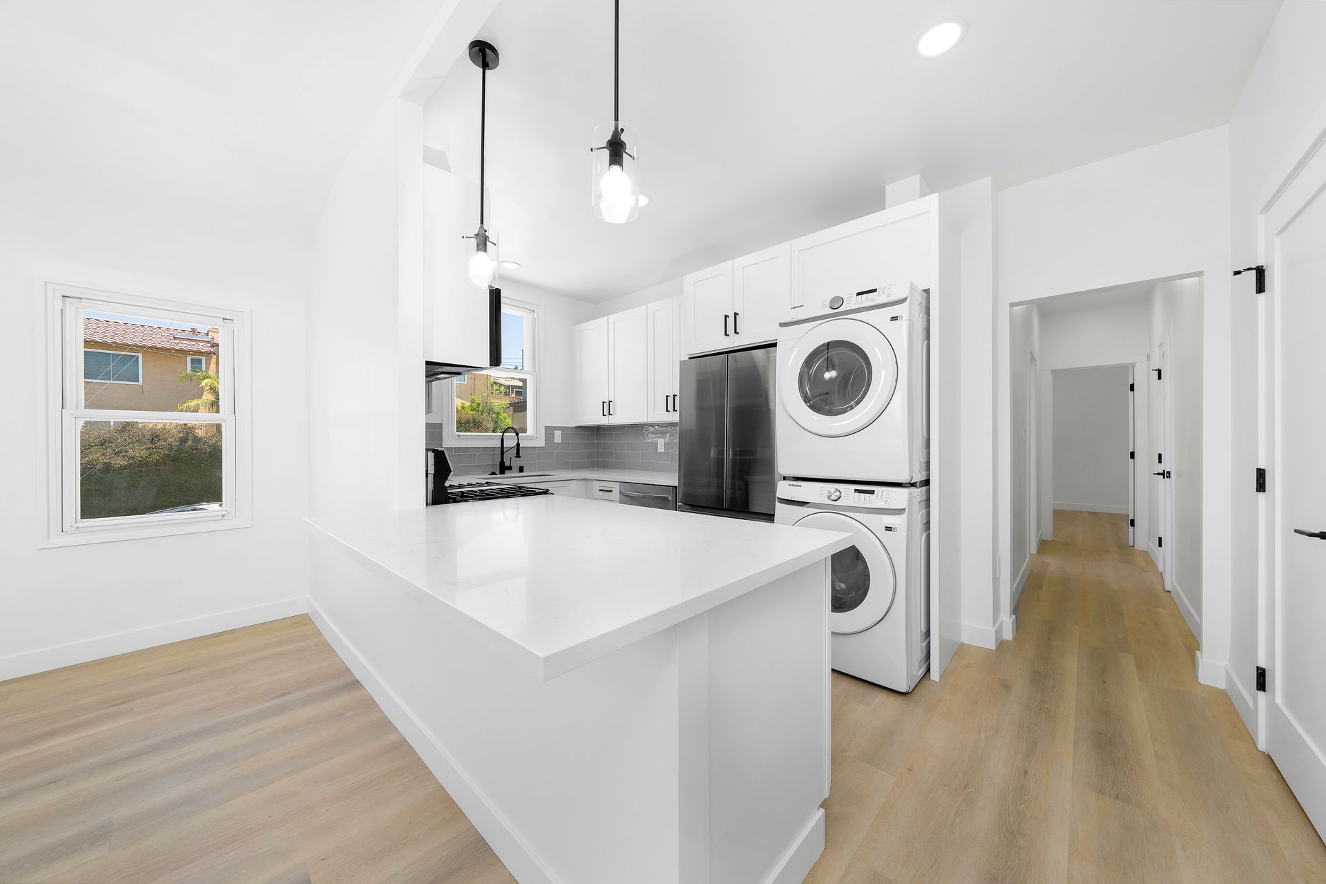 A kitchen with a washer and dryer stacked on top of each other.