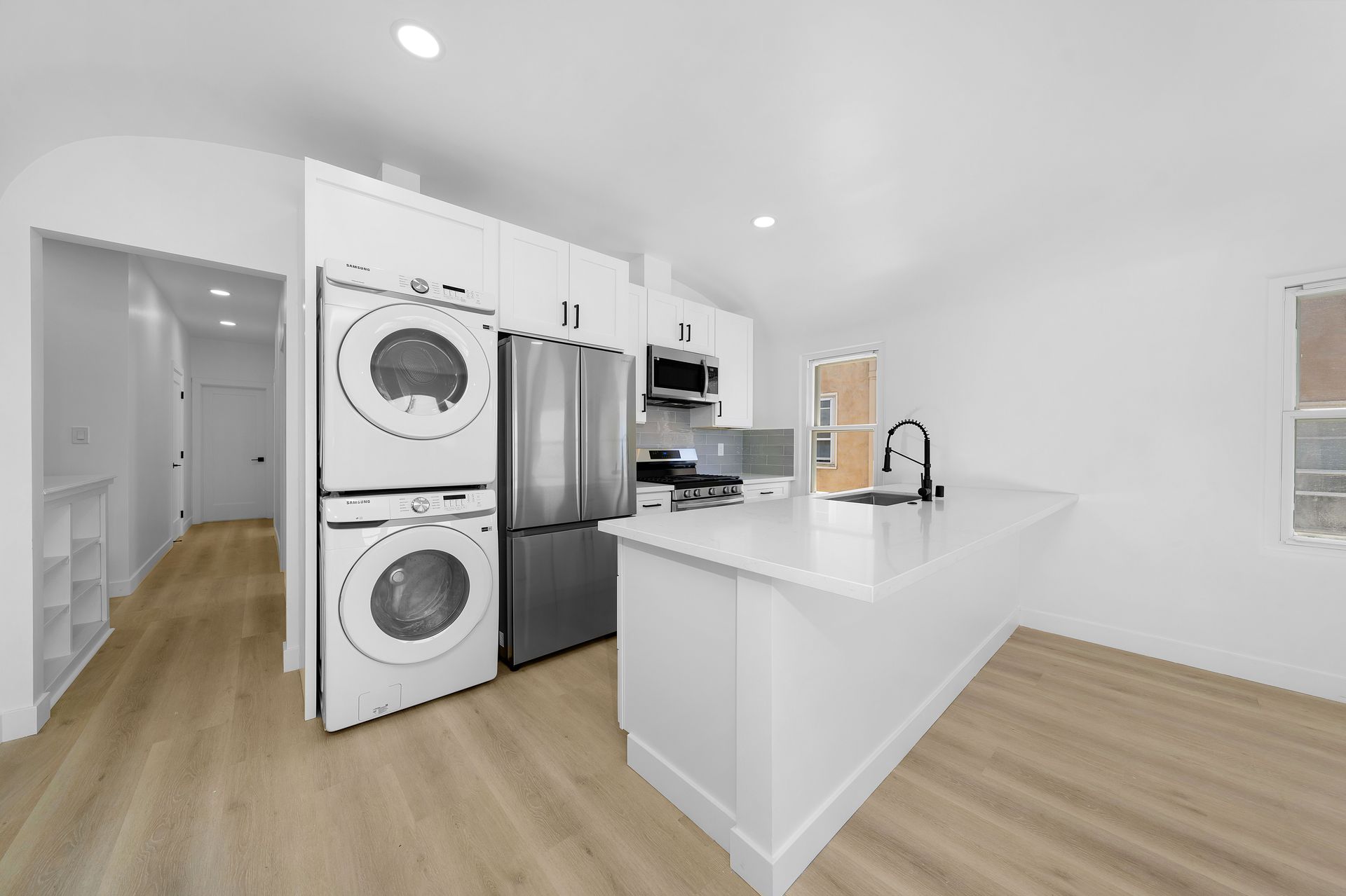 A kitchen with a washer and dryer stacked on top of each other.
