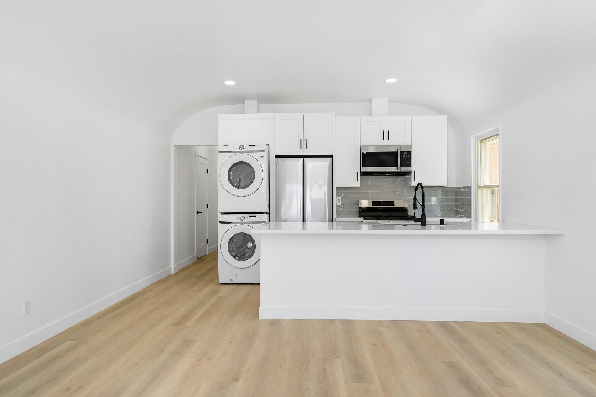 A kitchen with a washer and dryer stacked on top of each other.