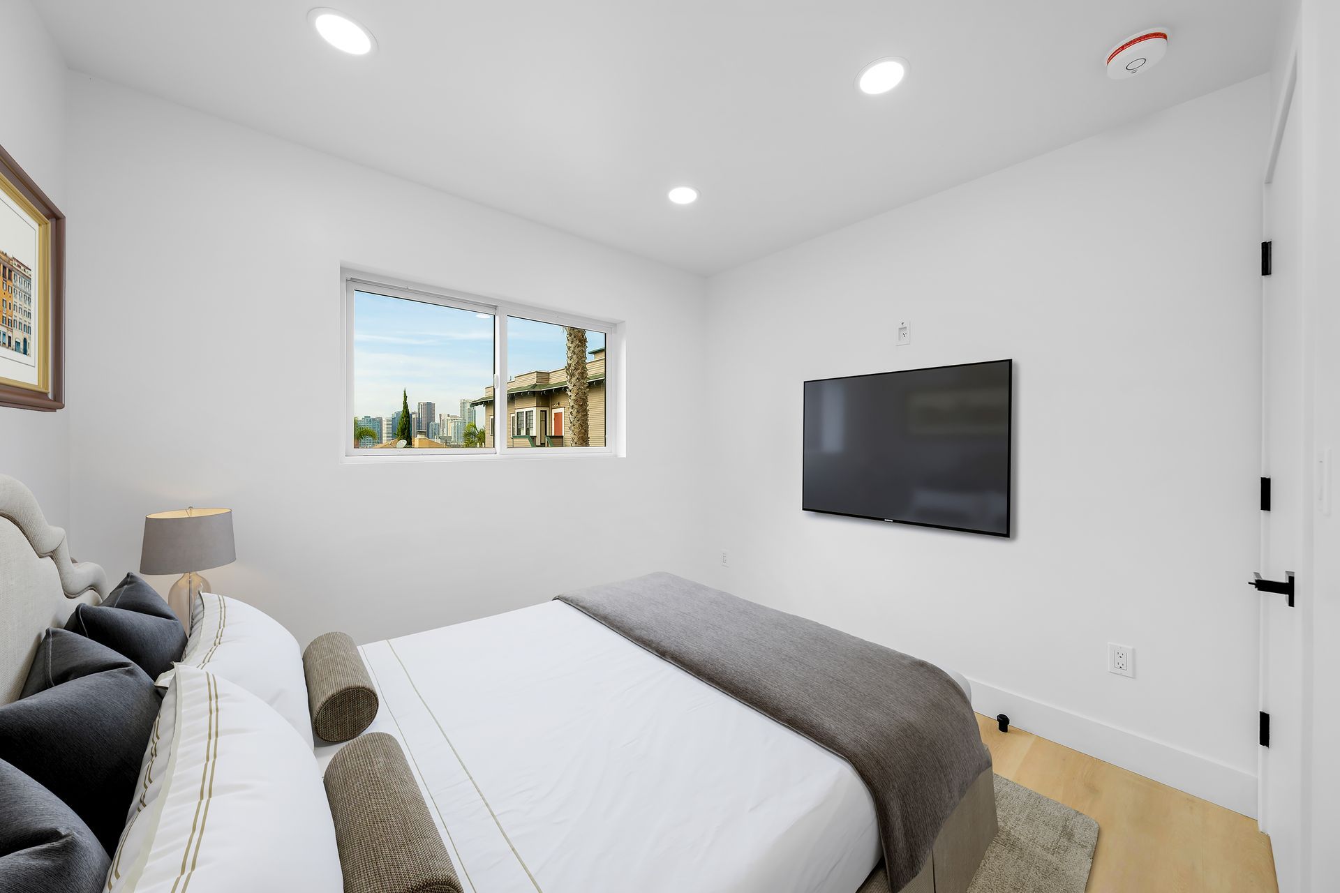 A bedroom with a king size bed and a flat screen tv on the wall.