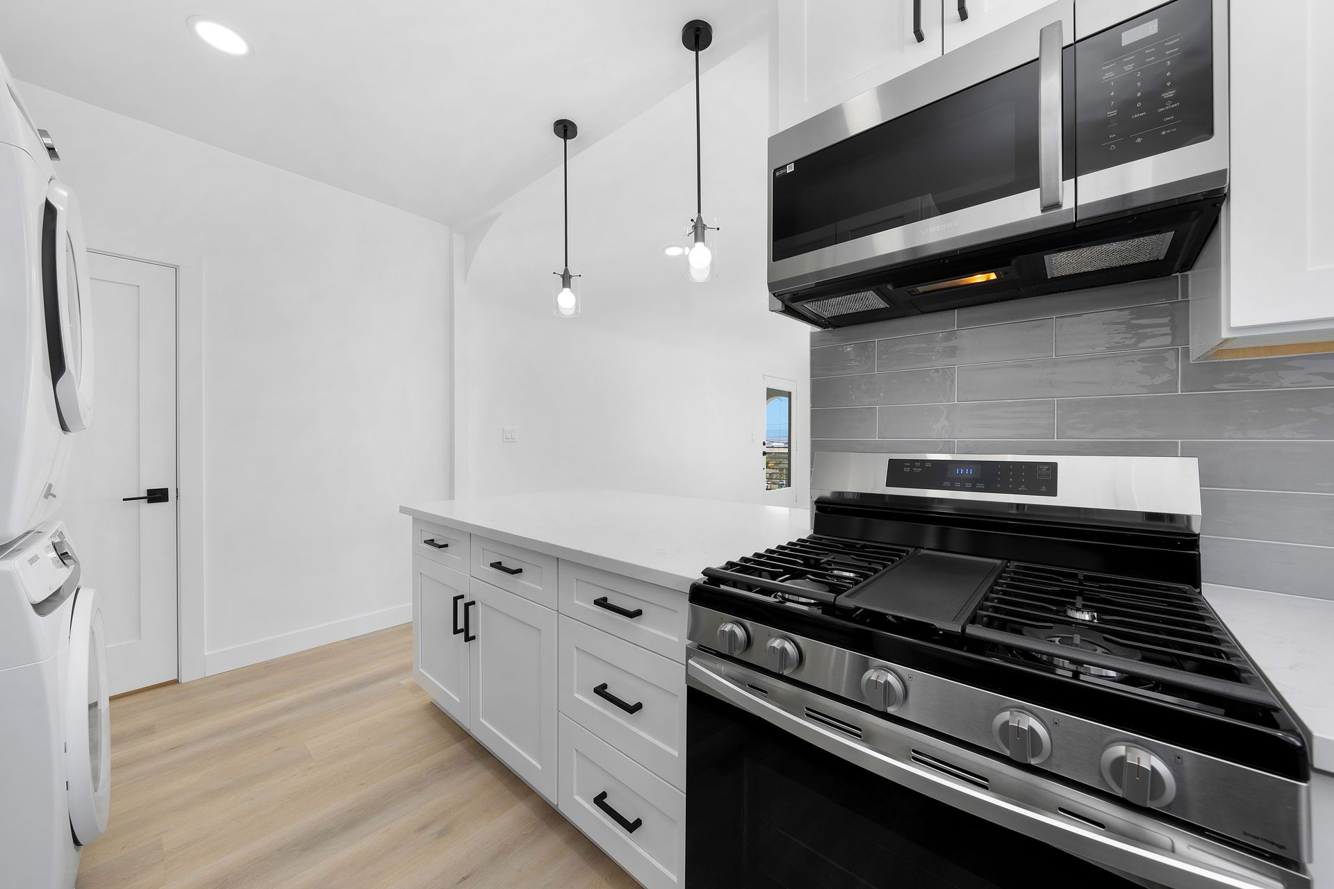 A kitchen with a stove , microwave , and refrigerator.