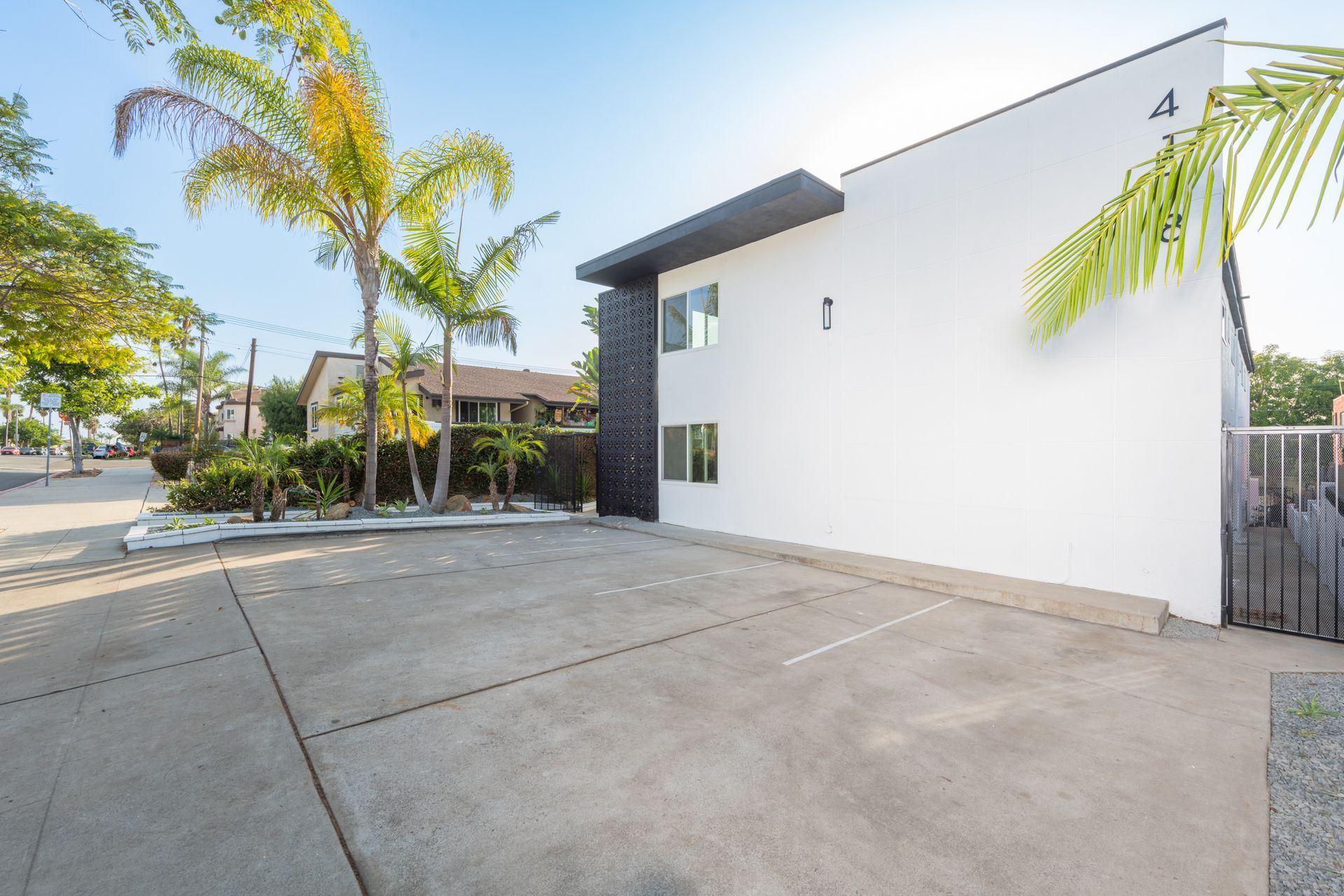 A white building with a parking lot in front of it