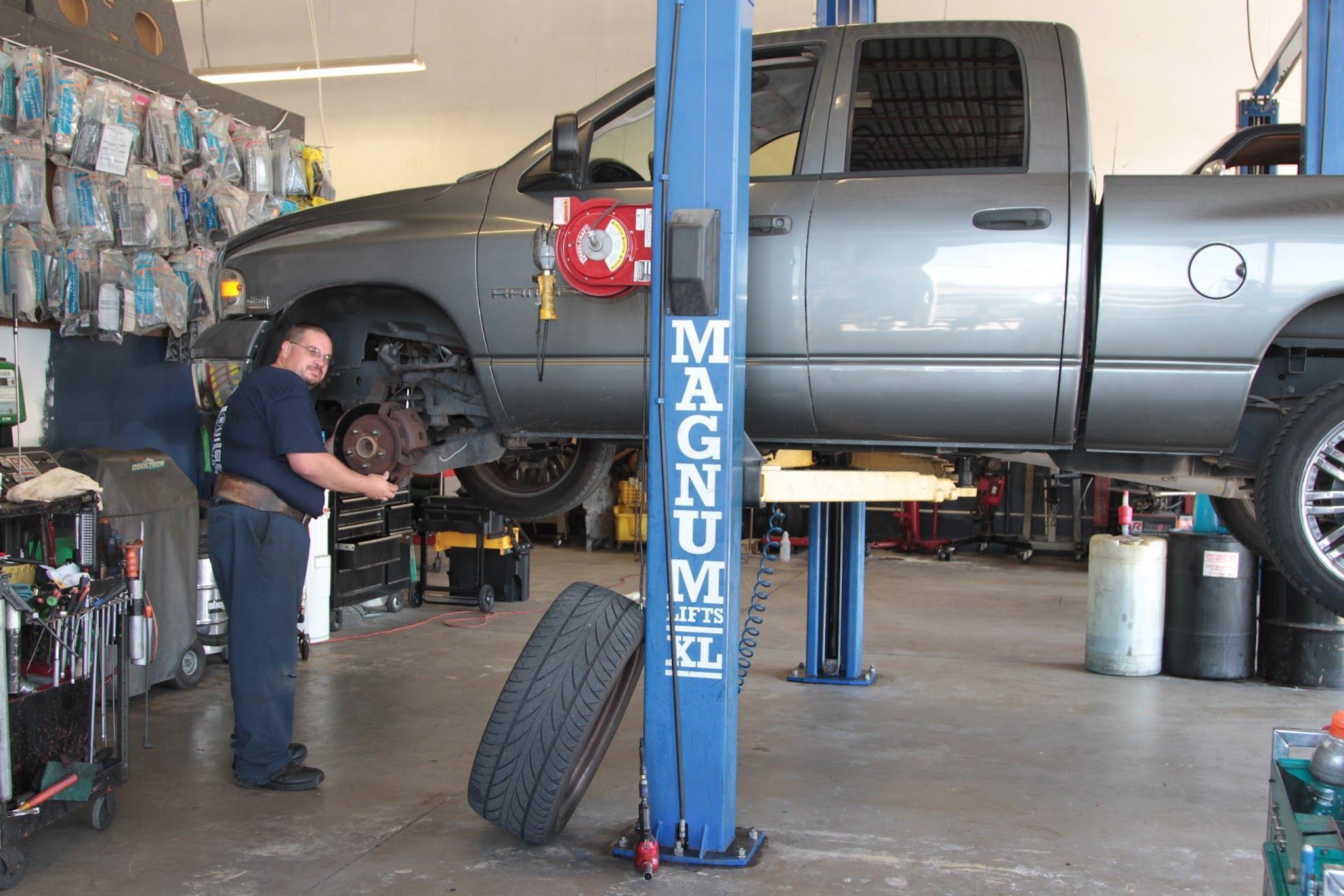 Mechanic working on a gray truck lifted | St. Lucie Auto Dynamics
