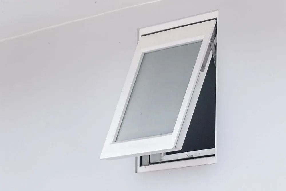 Tilted white window open against a light gray wall