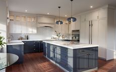 Bright modern kitchen with white cabinets, navy lower cabinets, island, and wood floors
