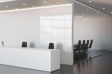 Modern glass conference room with white reception desk and black chairs