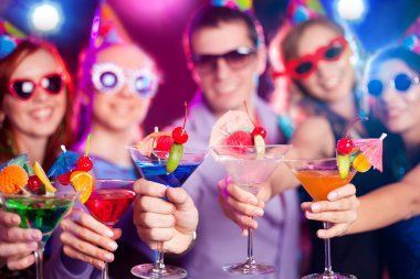 A group of people are holding martini glasses at a party.