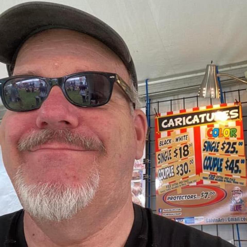 Smiling man in sunglasses and cap with a caricature pricing sign in the background
