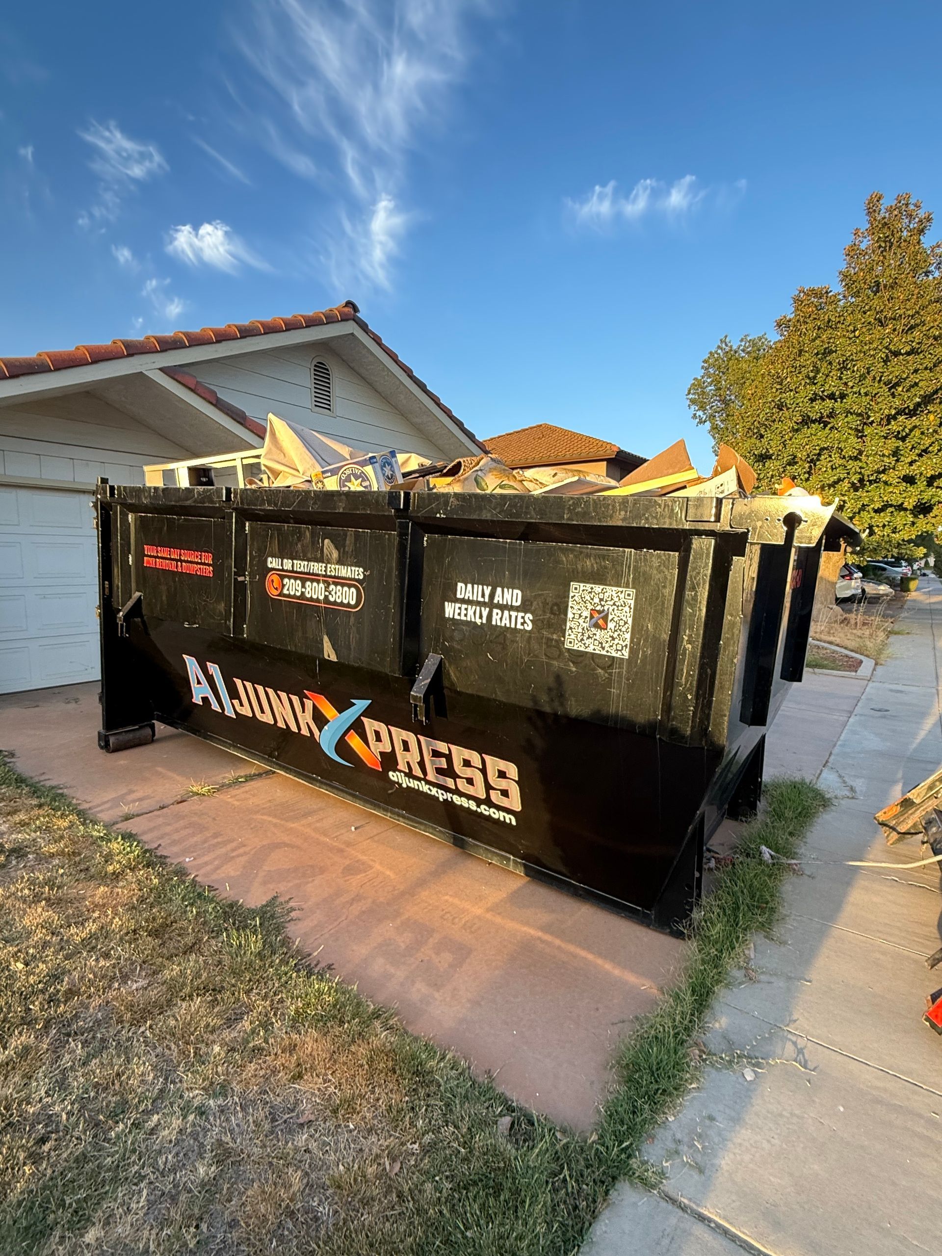 A large black dumpster labeled 