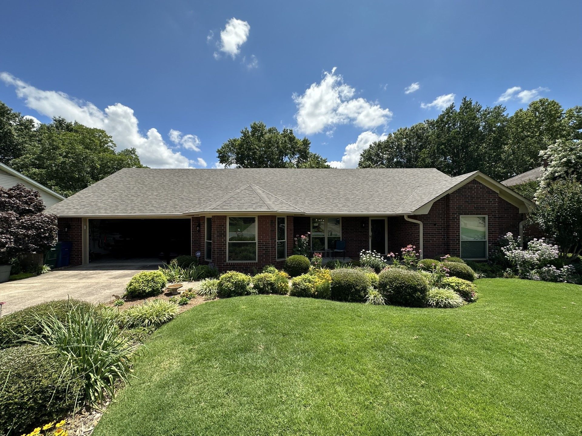 A brick house with a large lawn in front of it