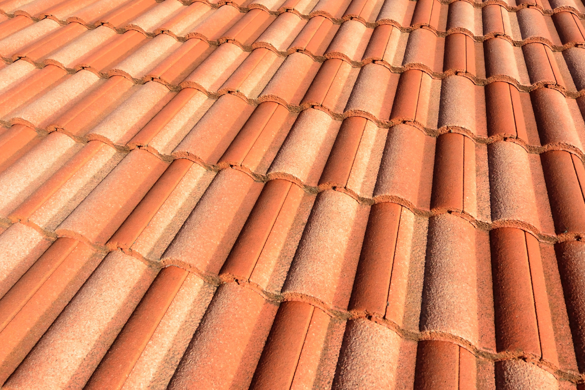 A close up of a row of red tiles on a roof