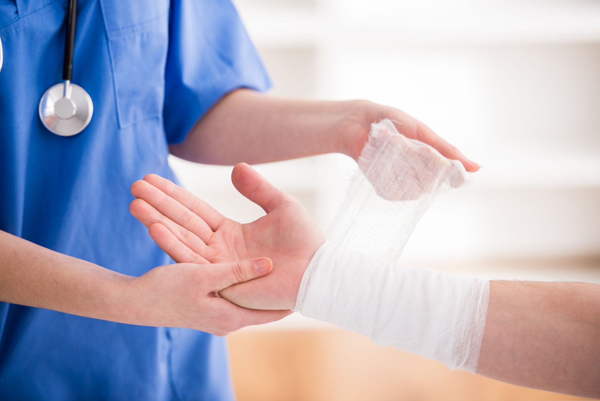 Eine Krankenschwester wickelt den Arm eines Patienten mit einem Verband