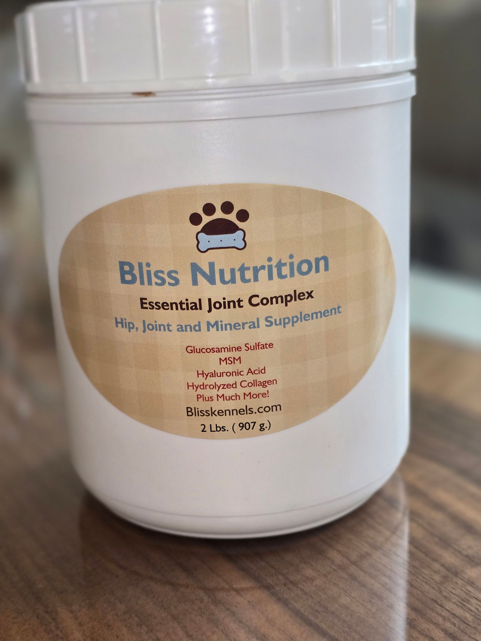 White Bliss Nutrition pet food container with tan label on a wooden table