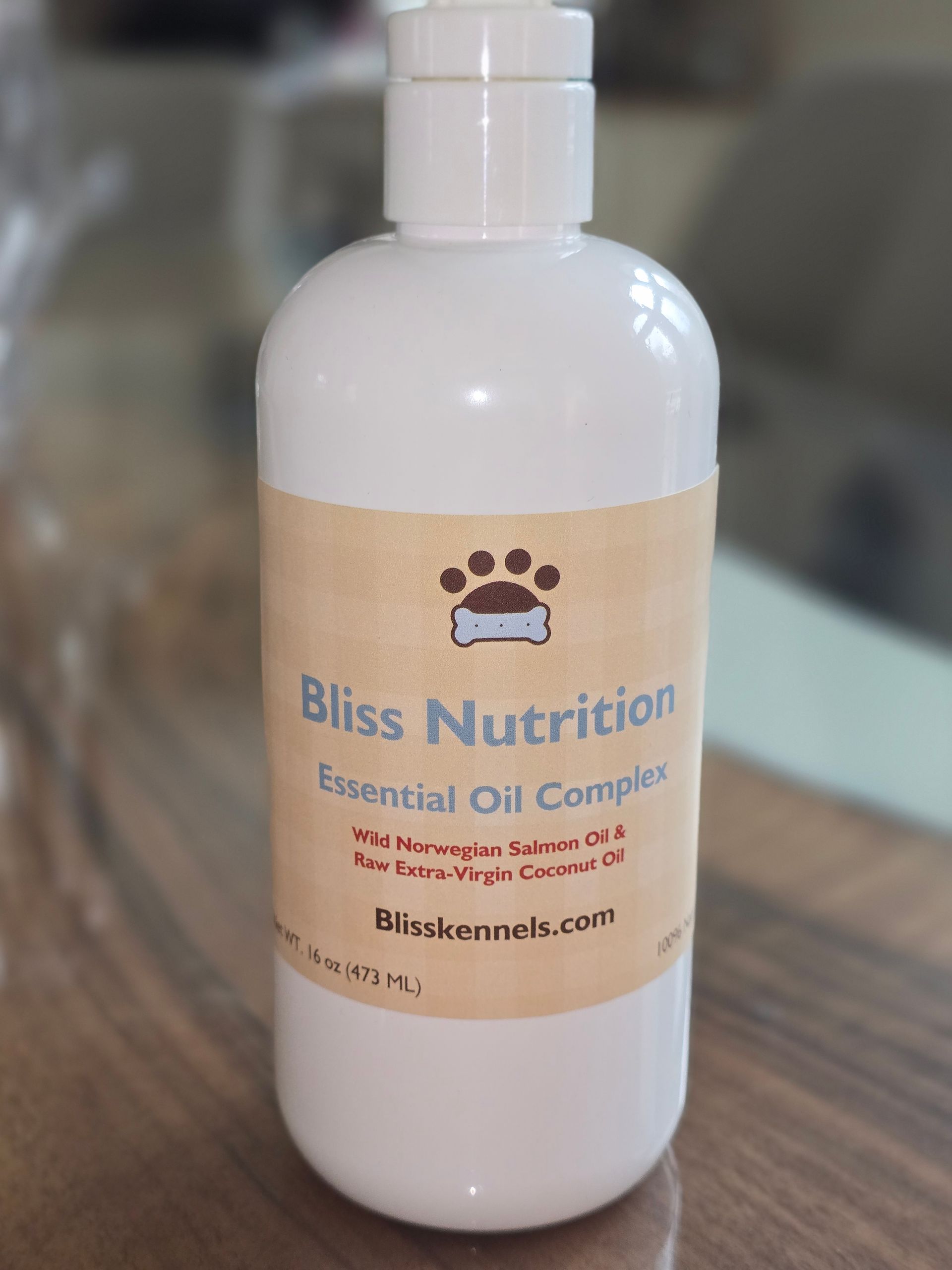 White Bliss Nutrition “Serious Oil Cares” bottle with white cap on a wooden table.