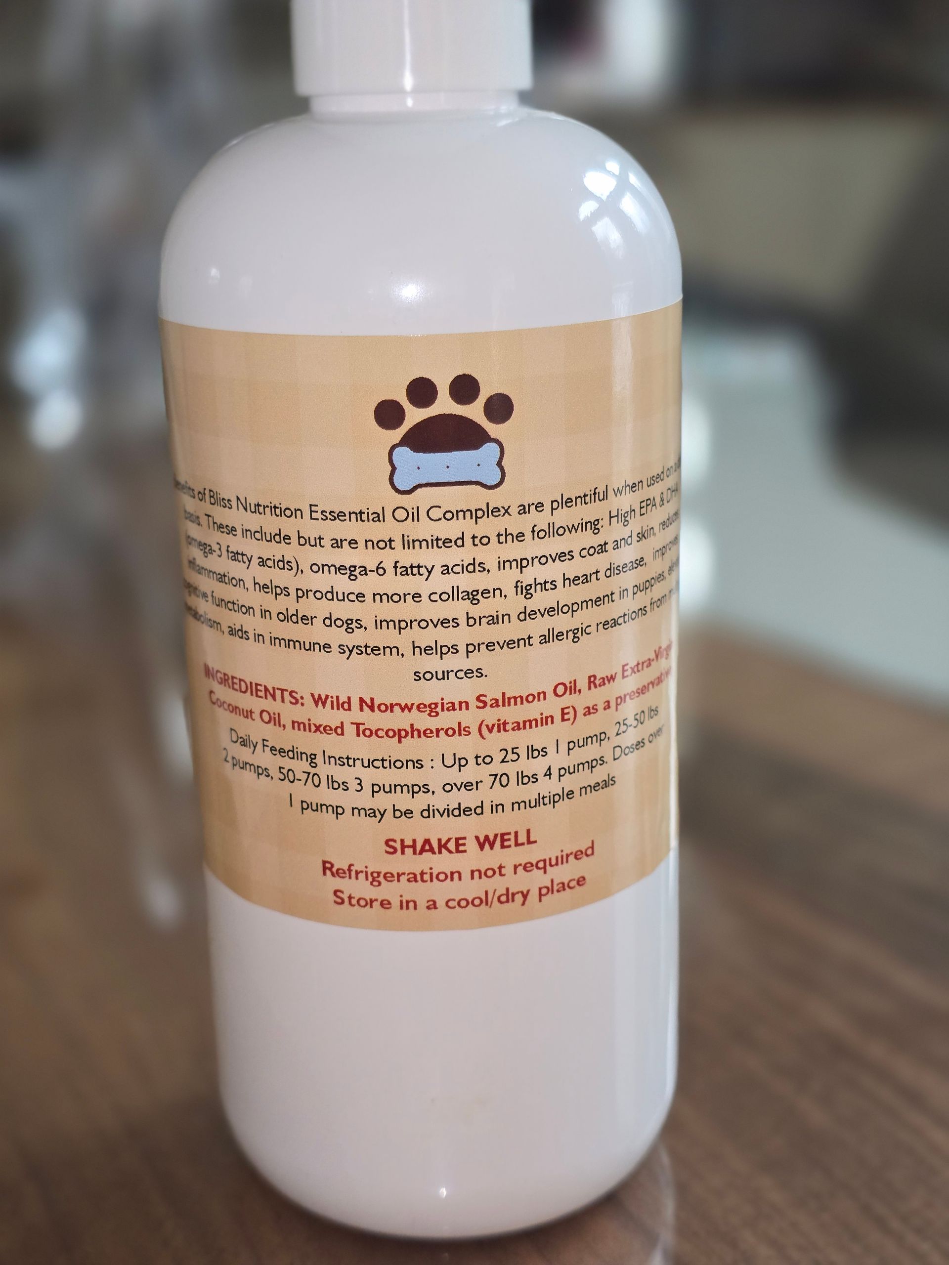 White plastic bottle with a tan label and paw print, standing upright on a wooden surface.