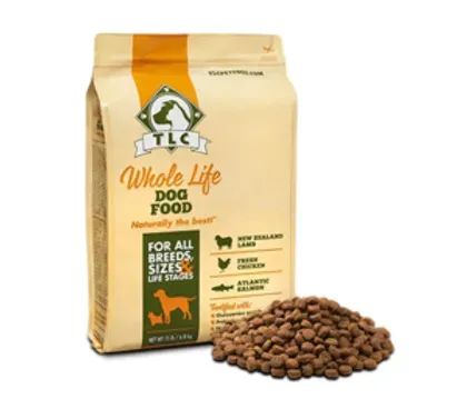 Bag of TLC Whole Life Dog Food with kibble spilled beside it on a white background