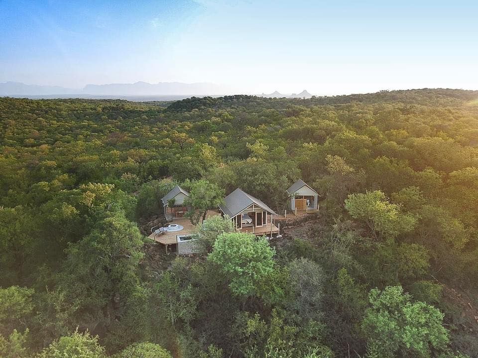 an aerial view of a house in the middle of a forest