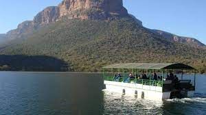 a boat is floating on a lake with a mountain in the background .
