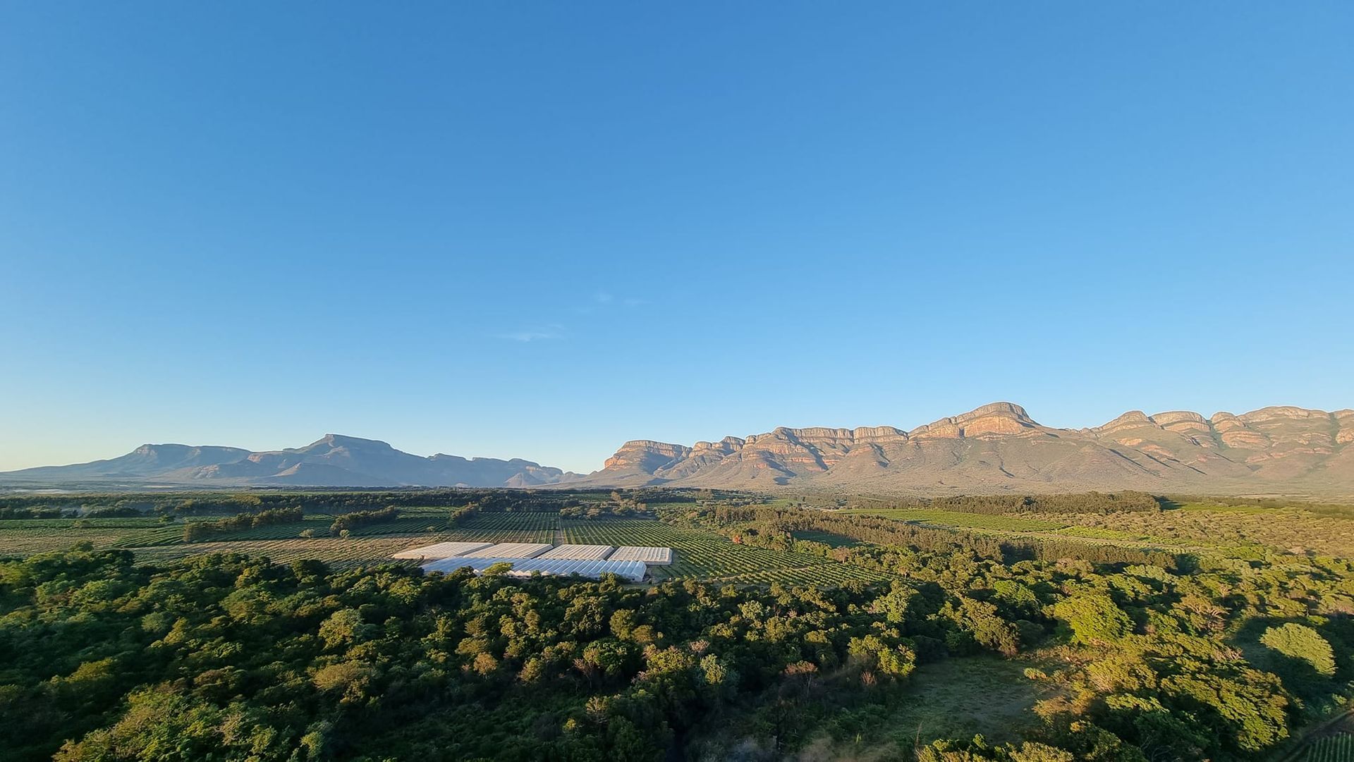 an aerial view of a valley with mountains in the background