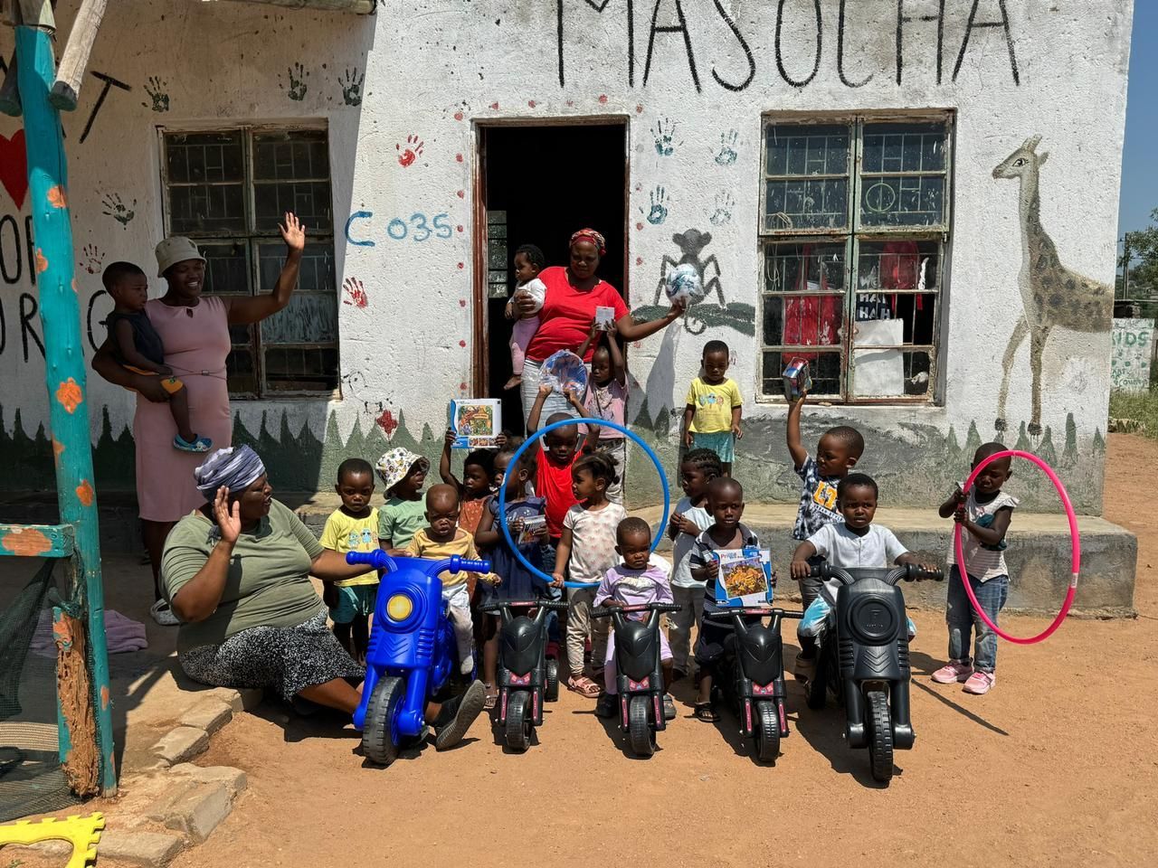 A group of children are posing for a picture in front of a building.