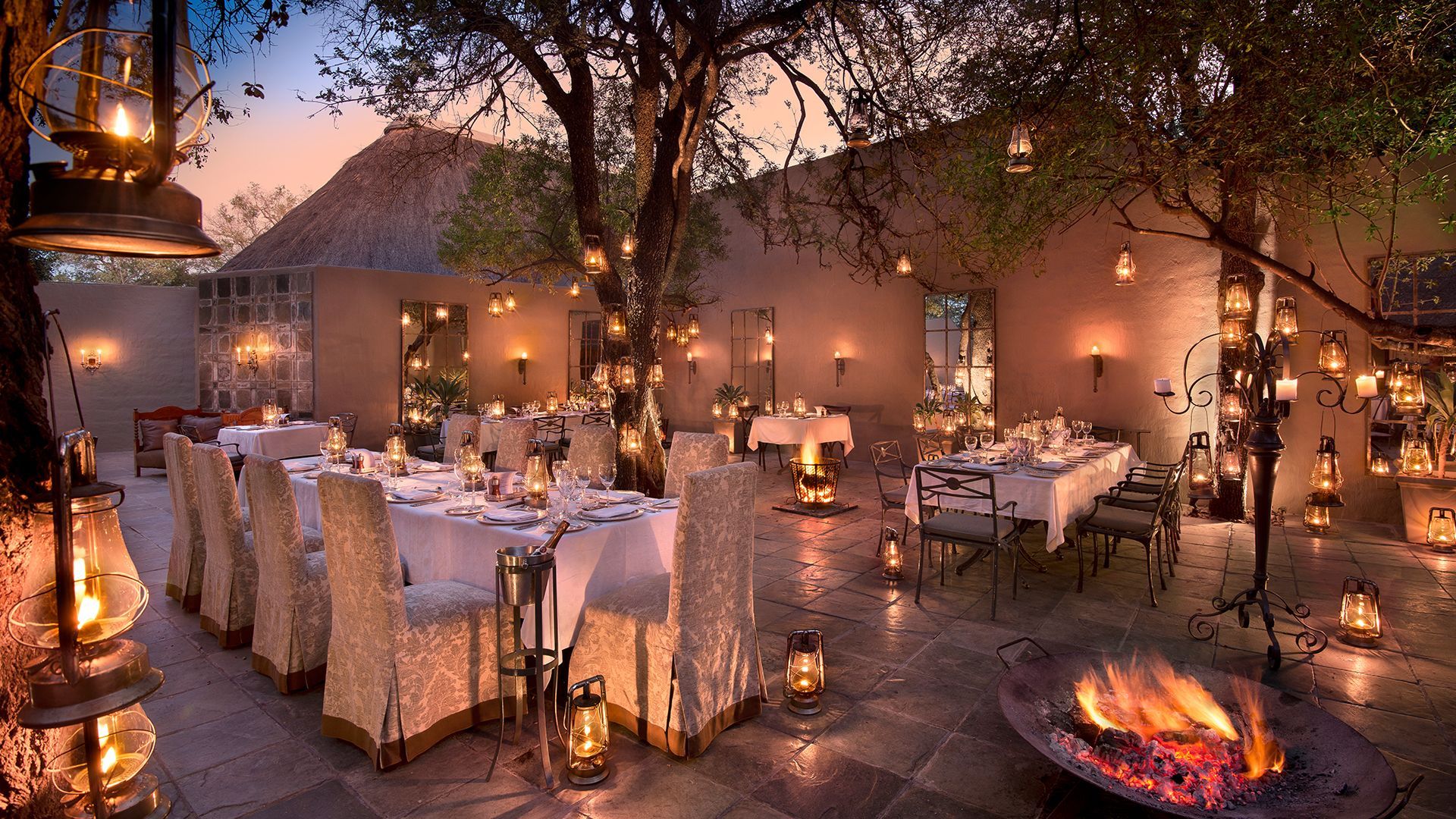 a dining room with tables and chairs and a fire pit .