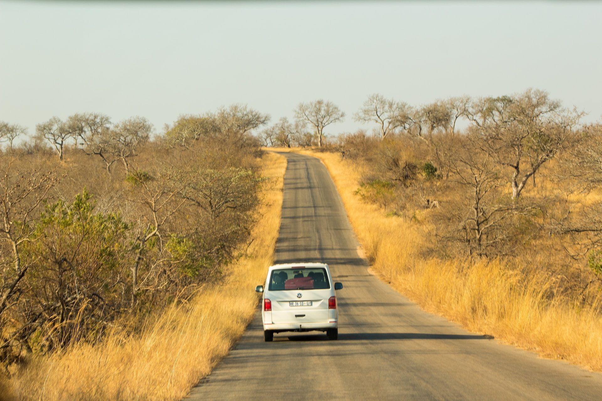 A white van is driving down a country road