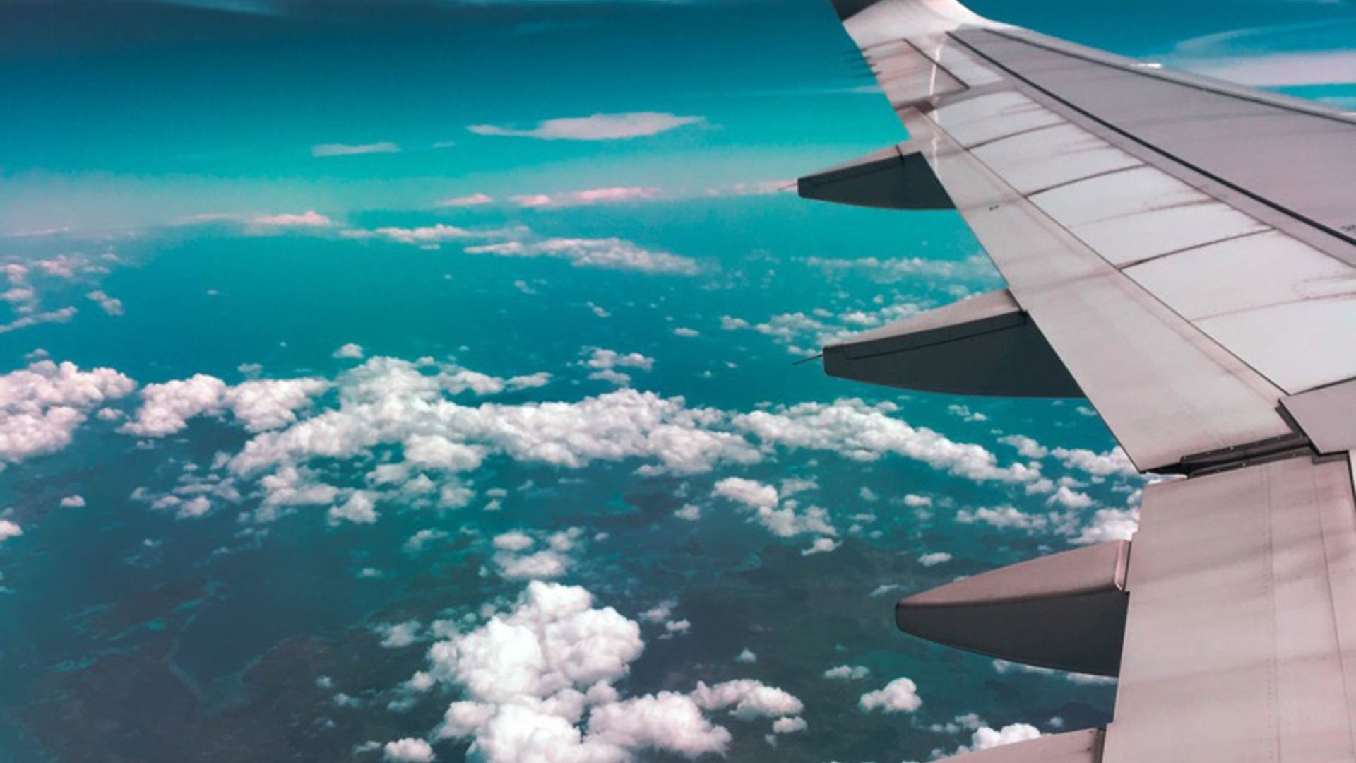 the wing of an airplane is flying through the clouds from cape town to hoedspruit
