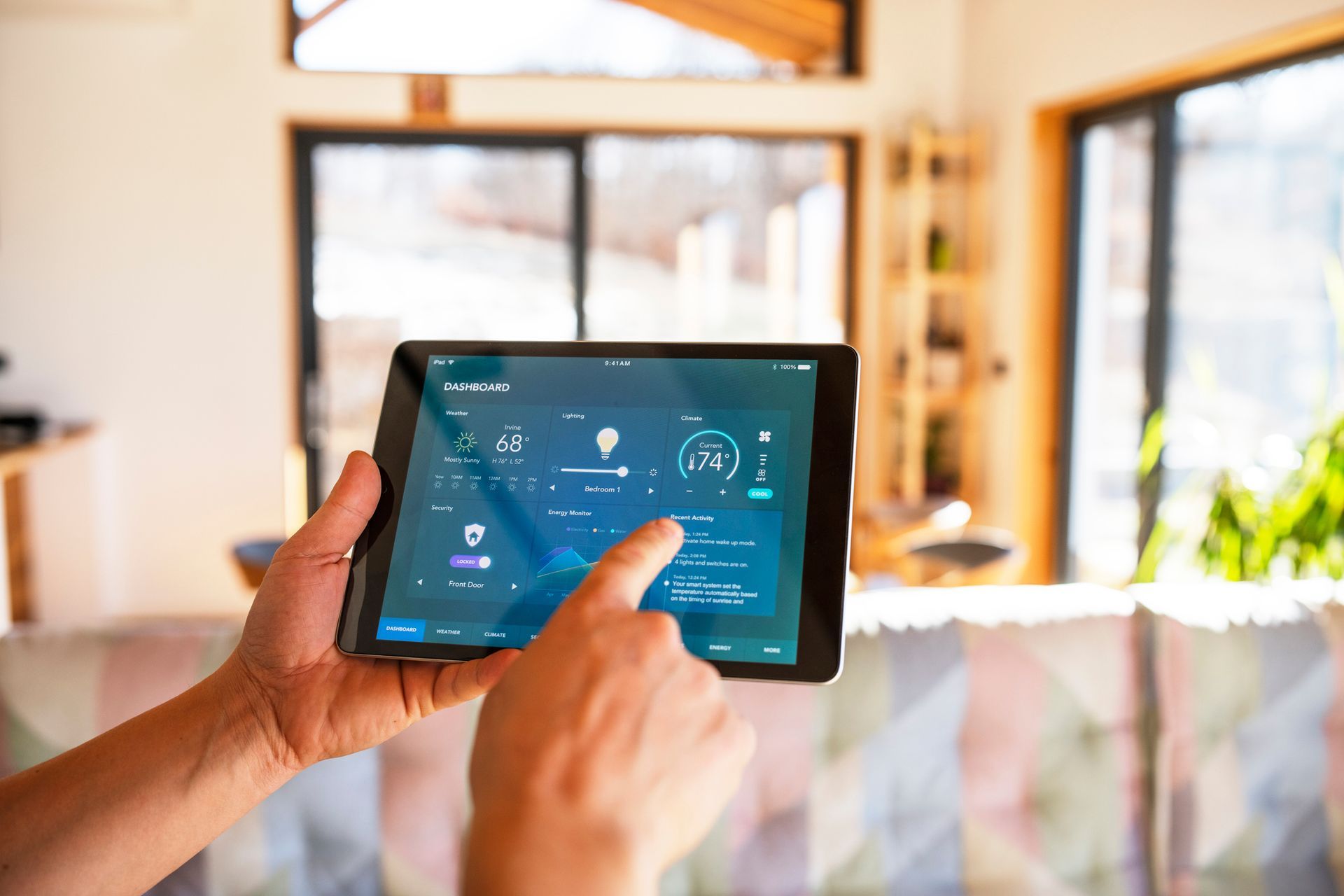 Persona che utilizza un tablet per controllare le funzioni della casa intelligente all'interno.