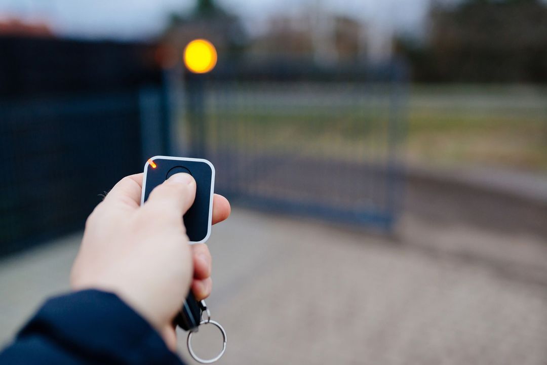 Persona che sblocca un cancello con uno smartphone, mostrando un'interfaccia di serratura digitale.