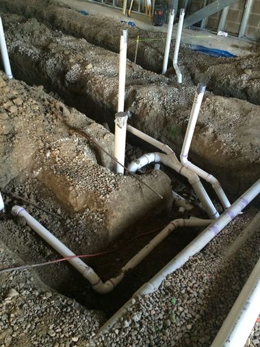 Commercial plumbers working on piping