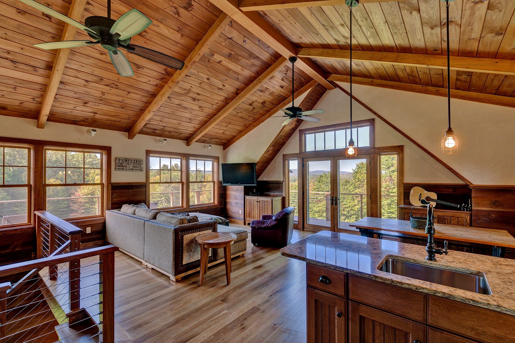 A living room with a ceiling fan and a kitchen