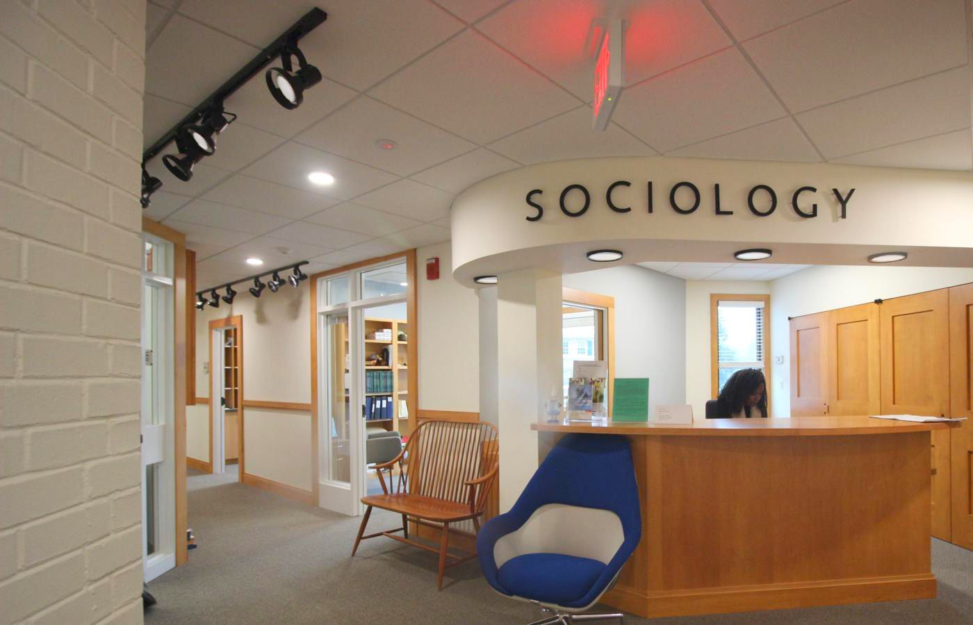 A blue chair sits in front of a sign that says sociology
