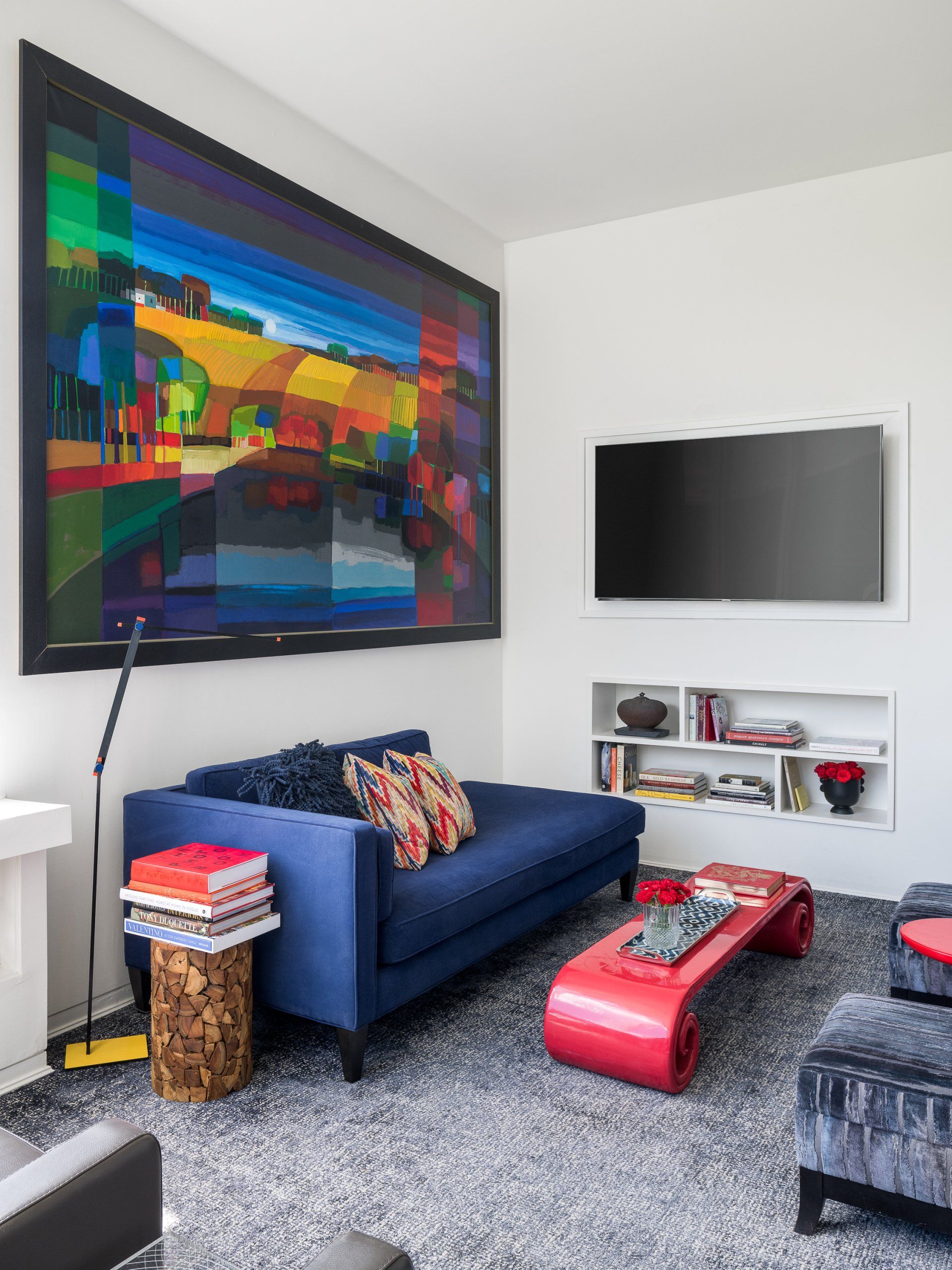 A living room with a blue couch and a red coffee table
