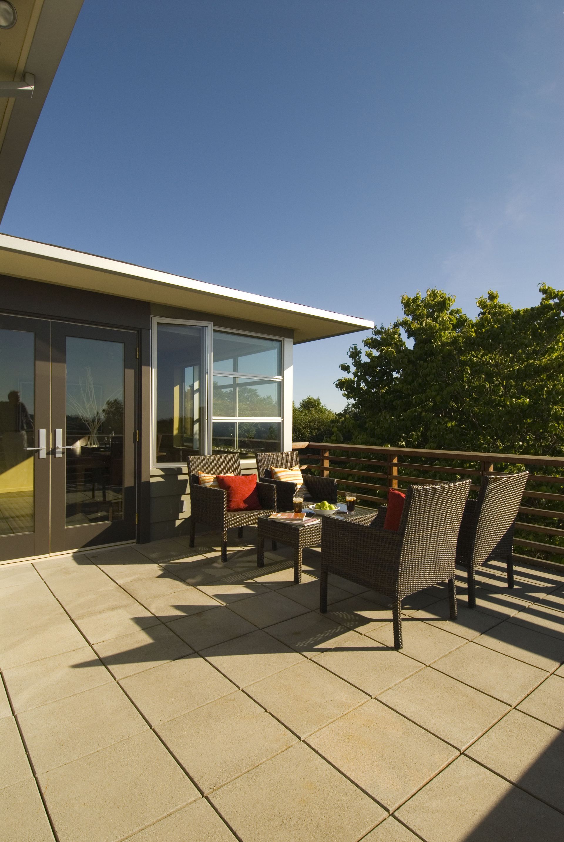 A balcony with chairs and a table in front of a house